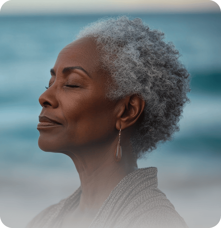 A woman meditating by the sea, eyes closed