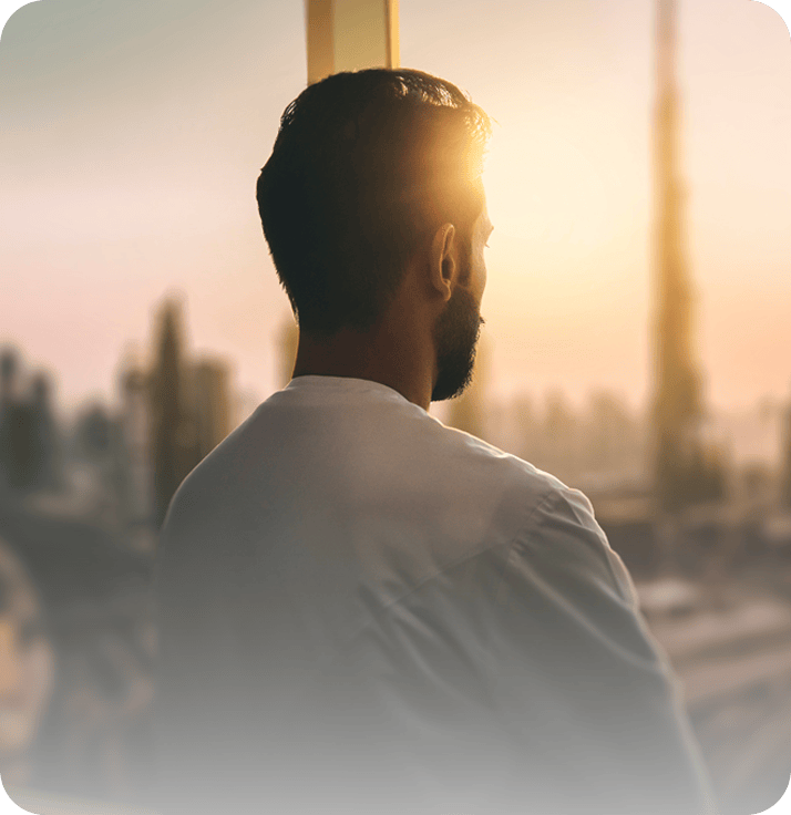 A man in white standing in quiet reflection